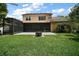 Large backyard showing the screened-in lanai, fire pit and green lawn at 612 Heron Bay Dr, Orlando, FL 32825