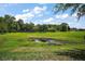 Green community area with mature trees, a pond, a foot bridge, and well-manicured landscaping at 612 Heron Bay Dr, Orlando, FL 32825