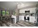 Modern kitchen with stainless steel appliances, white cabinetry, and a cozy dining area with natural light at 612 Heron Bay Dr, Orlando, FL 32825