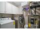 Laundry room with shelving, side by side washer and dryer, and hot water tank at 612 Heron Bay Dr, Orlando, FL 32825