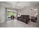 Comfortable living room with tile flooring, neutral walls, and a cozy couch near the screened patio at 612 Heron Bay Dr, Orlando, FL 32825