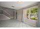 Bright living room featuring tile flooring, staircase, and natural light from a large window at 612 Heron Bay Dr, Orlando, FL 32825