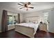 Cozy main bedroom featuring a large bed, dark wood floors, and natural light from multiple windows at 612 Heron Bay Dr, Orlando, FL 32825
