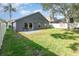 A fenced backyard with well-maintained lawn, string lights and a patio area with chairs at 637 Blenheim Loop, Winter Springs, FL 32708