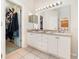 Bright bathroom with dual sinks, white cabinets, tile flooring, and walk-in closet at 637 Blenheim Loop, Winter Springs, FL 32708