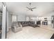 Open-concept living room with tile flooring, ceiling fan, and large gray leather sectional sofa at 637 Blenheim Loop, Winter Springs, FL 32708