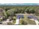 Wide aerial view of the home with the lawn, driveway and trees and a neighboring home at 6691 Sw 151Sr Loop, Ocala, FL 34473