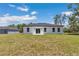 Back exterior view of home, featuring a lush green lawn and modern construction at 6691 Sw 151Sr Loop, Ocala, FL 34473