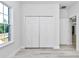 This bedroom has light hardwood floors, a closet with double doors, and a window at 6691 Sw 151Sr Loop, Ocala, FL 34473