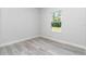Bedroom with light gray wood flooring and a large window at 6691 Sw 151Sr Loop, Ocala, FL 34473