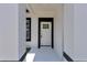 Inviting view of the front door featuring modern design elements, a white frame, and black trim at 6691 Sw 151Sr Loop, Ocala, FL 34473