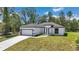 Attractive single-story home with an attached garage, white exterior and freshly installed lawn at 6691 Sw 151Sr Loop, Ocala, FL 34473