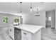 Open kitchen area with white cabinets, stainless steel appliances, a large island, and a view to the backyard at 6691 Sw 151Sr Loop, Ocala, FL 34473