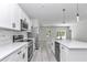 Contemporary kitchen boasting stainless steel appliances, quartz countertops, island with sink, and bright white cabinetry at 6691 Sw 151Sr Loop, Ocala, FL 34473