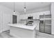 Well-lit kitchen with white cabinetry, quartz countertops, stainless steel appliances, and an island with a sink at 6691 Sw 151Sr Loop, Ocala, FL 34473