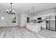 Open concept living area with kitchen, complete with stainless steel appliances, quartz countertops and modern lighting at 6691 Sw 151Sr Loop, Ocala, FL 34473