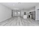 Open concept living room features light gray wood flooring and leads into a modern kitchen at 6691 Sw 151Sr Loop, Ocala, FL 34473