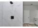 The walk-in shower features marble tiling and a black showerhead at 6691 Sw 151Sr Loop, Ocala, FL 34473