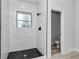 The walk-in shower features a black showerhead and mosaic-tiled floors at 6691 Sw 151Sr Loop, Ocala, FL 34473