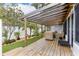Inviting backyard showcasing a wood deck, covered pergola, and lush artificial turf at 674 Douglas Ave, Winter Park, FL 32789