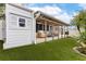 A charming backyard features lush artificial turf, covered patio, and privacy fence at 674 Douglas Ave, Winter Park, FL 32789
