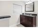 Simple bathroom featuring a dark vanity, a large mirror, a granite countertop and tile floors at 674 Douglas Ave, Winter Park, FL 32789