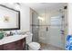 Modern bathroom featuring a glass-enclosed shower, elegant vanity, and neutral tile with decorative accents at 674 Douglas Ave, Winter Park, FL 32789