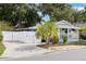 Charming home featuring a blue door, white picket fence, well-manicured landscaping, and a private, fenced driveway at 674 Douglas Ave, Winter Park, FL 32789