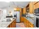 Open kitchen featuring granite countertops, stainless appliances, and terracotta tile flooring at 674 Douglas Ave, Winter Park, FL 32789