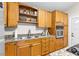 Well-lit kitchen featuring granite countertops, wood cabinetry, and stainless steel appliances at 674 Douglas Ave, Winter Park, FL 32789