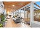 Inviting sunroom featuring wood-paneled ceilings, a stone fireplace, and floor-to-ceiling glass at 674 Douglas Ave, Winter Park, FL 32789