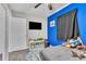View of the bedroom space with blue accent wall, window and grey floors at 7033 Budapest Way, Orlando, FL 32822