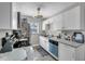 Well-lit kitchen featuring stainless steel appliances, white cabinets, and granite countertops at 7033 Budapest Way, Orlando, FL 32822