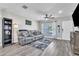Comfortable living room with wood-look floors, gray sectional, and abundant natural light at 7033 Budapest Way, Orlando, FL 32822