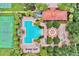 Aerial view of a community pool, tennis court, playground, and clubhouse amid lush greenery at 707 N Marotta Loop, Ocoee, FL 34761