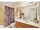 Bathroom featuring single sink vanity with framed mirror, tub and shower combo and light fixtures at 707 N Marotta Loop, Ocoee, FL 34761