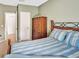 Relaxing bedroom offers a striped bedspread and a wood dresser with easy access to the hallway at 707 N Marotta Loop, Ocoee, FL 34761