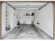 Spacious two car garage with concrete floors, white walls, and ample storage shelving at 707 N Marotta Loop, Ocoee, FL 34761