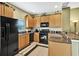 Well-equipped kitchen featuring sleek black appliances and tile flooring at 707 N Marotta Loop, Ocoee, FL 34761