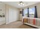 Comfortable bedroom with large window, white bookshelf and a spacious closet at 724 Duff Dr, Winter Garden, FL 34787