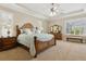 Elegant main bedroom suite with tray ceilings, plush carpeting, and natural light from shuttered windows at 724 Duff Dr, Winter Garden, FL 34787