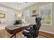 Inviting home office with a classic desk, comfortable seating, and natural light from large windows at 724 Duff Dr, Winter Garden, FL 34787