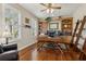 Well-lit office featuring custom wood built-ins, hardwood floors, plantation shutters and comfortable seating at 724 Duff Dr, Winter Garden, FL 34787