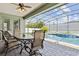 Outdoor patio featuring a dining table, chairs, and a screened-in pool area with spa for seamless indoor/outdoor living at 724 Duff Dr, Winter Garden, FL 34787