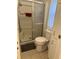Cozy bathroom featuring a shower with glass doors, a toilet, and built-in storage for convenience at 816 Polo Park East Blvd, Davenport, FL 33897