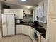 Well-lit kitchen with white cabinets, appliances, and tile flooring at 816 Polo Park East Blvd, Davenport, FL 33897