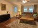 Inviting living room boasts wood floors, a plush sofa with throw pillows, and abundant natural light at 816 Polo Park East Blvd, Davenport, FL 33897