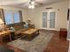 Spacious living room boasts wood floors, a plush sofa, and bright natural light from french doors at 816 Polo Park East Blvd, Davenport, FL 33897