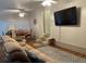 Spacious living room featuring hardwood floors, cozy furniture, a large TV, and access to the dining area at 816 Polo Park East Blvd, Davenport, FL 33897