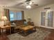 Spacious living room with wood floors, a plush sofa, a ceiling fan, and ample natural light at 816 Polo Park East Blvd, Davenport, FL 33897